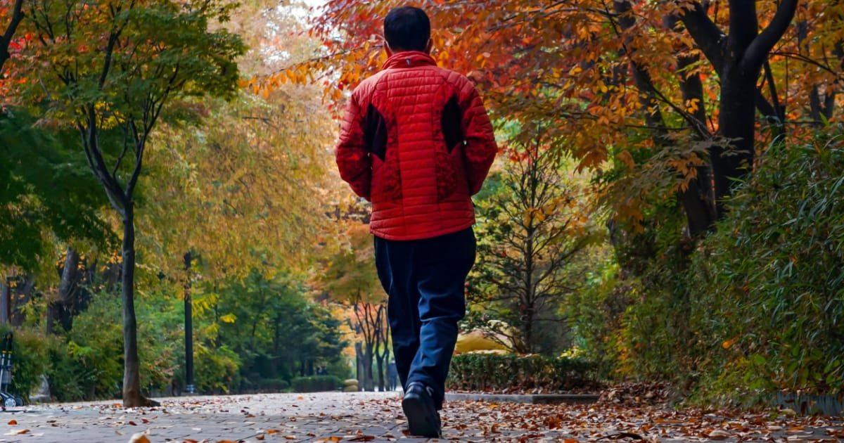Man in his 40s walking alone on a quiet path
