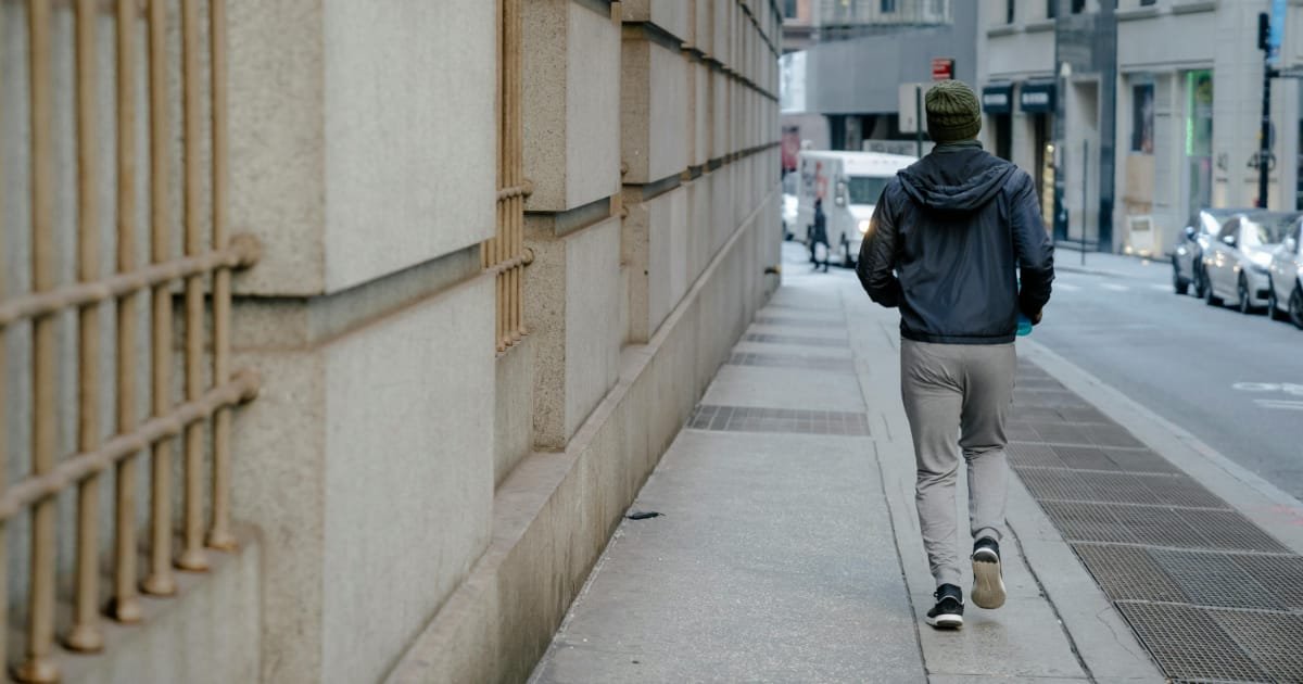 Man walking alone on a city sidewalk during the day