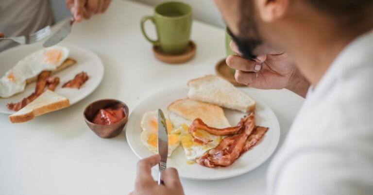 Man over 40 eating a protein-rich breakfast of eggs at a kitchen table in the morning