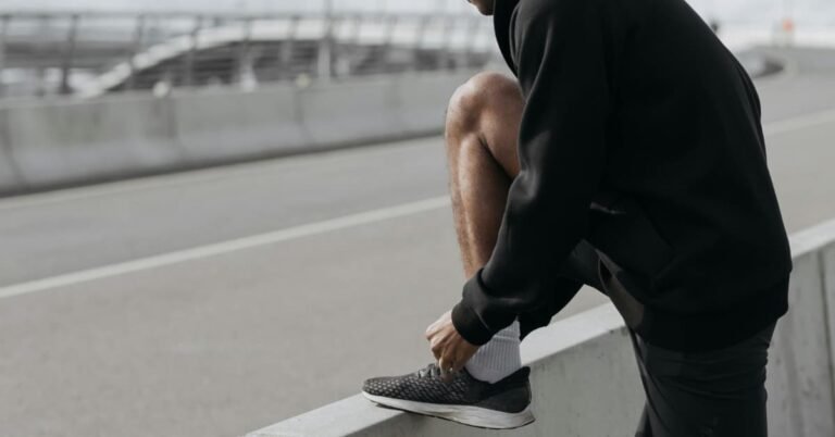 Man over 40 lacing up walking shoes in the morning as part of a daily health routine