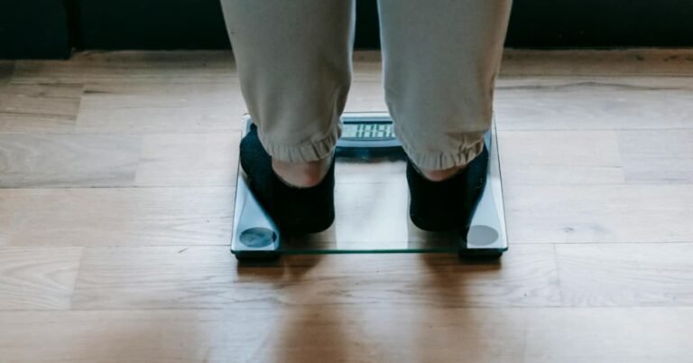 Man over 40 standing on a bathroom scale checking his weight loss progress in the morning