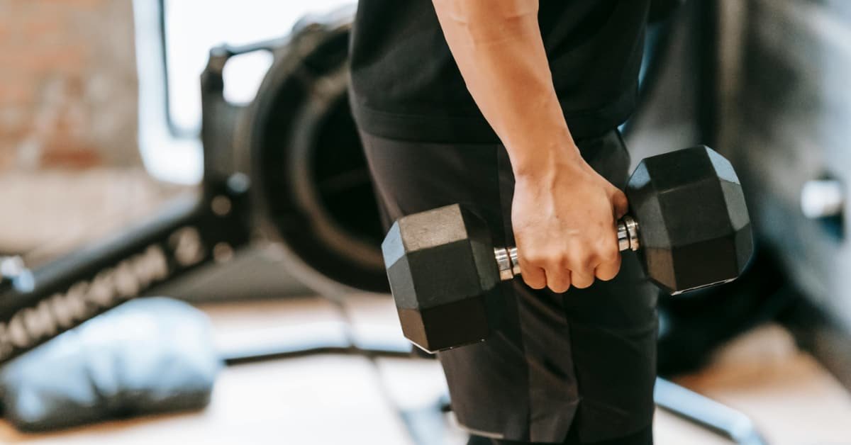 Man over 40 performing a dumbbell row during a strength training session in a home gym