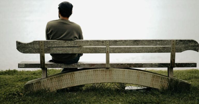 Man over 40 sitting quietly outdoors, reflecting on mental health and wellbeing in midlife