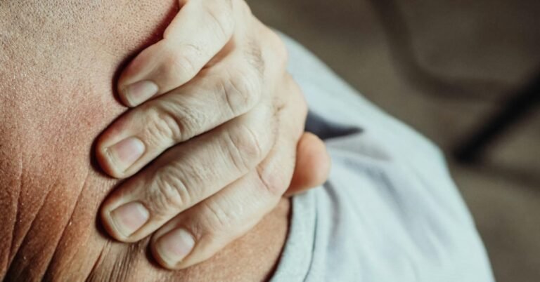 Man over 45 stretching his neck and back at a home desk after long hours of sitting