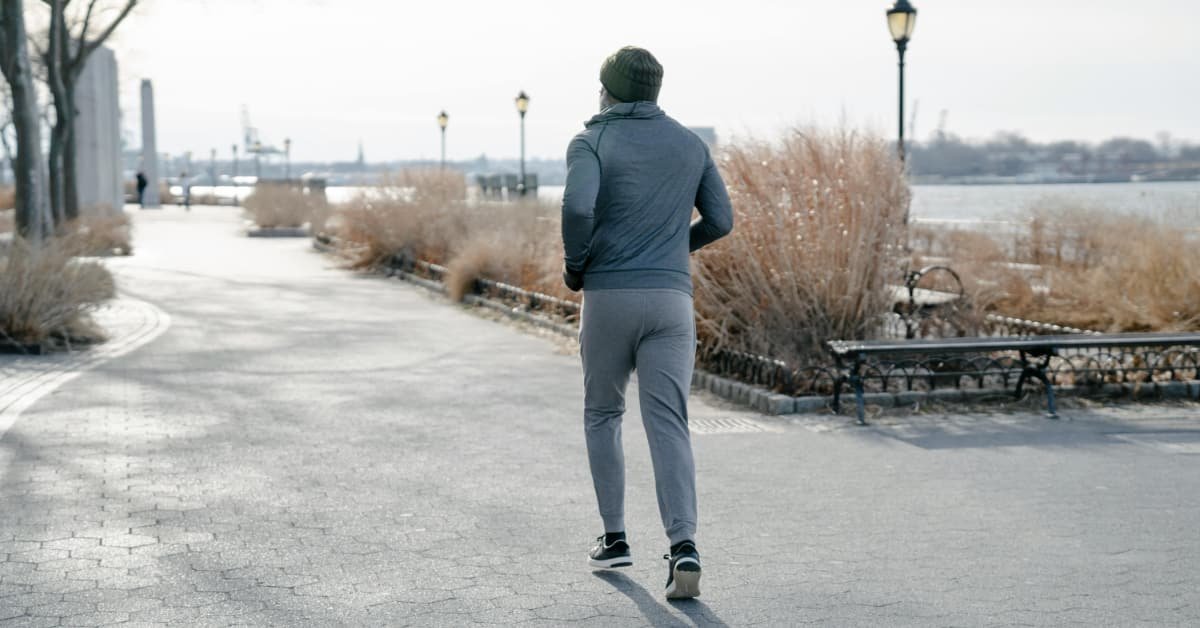 Man walking outdoors comparing walking and jogging after 40