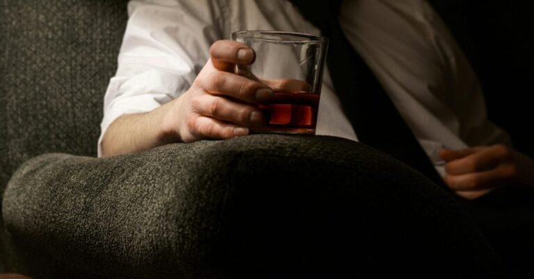 Man over 40 considering a glass of wine, reflecting on how alcohol affects the body differently in midlife