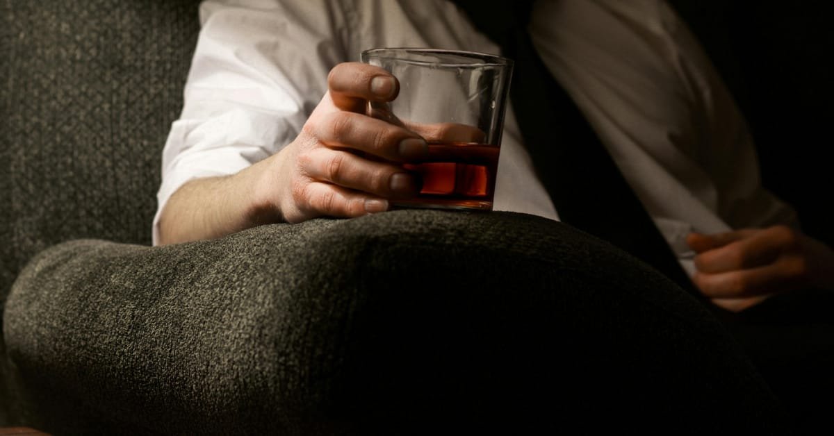 Man over 40 considering a glass of wine, reflecting on how alcohol affects the body differently in midlife